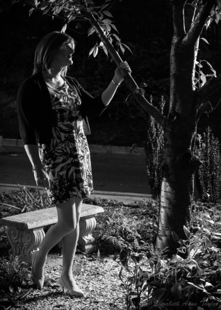 In this black and white photo, Allison grabs onto a branch of the cherry tree.